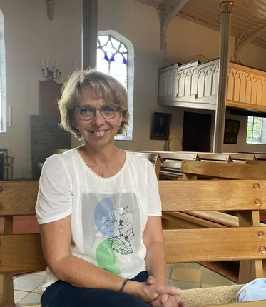 Eine Frau, sitzend in einer Kirche